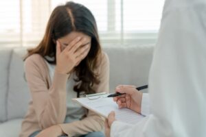 A woman with mental health problems is consulting with a psychiatrist, who is recording her condition for treatment.