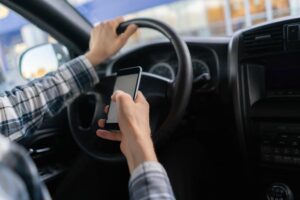 Male driver in the vehicle using the smartphone