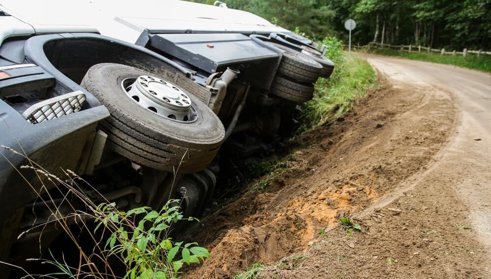 The truck is lying on its side in a accident