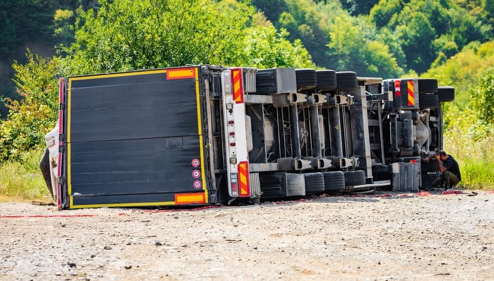 Large cargo truck turned over on road traffic accident at day