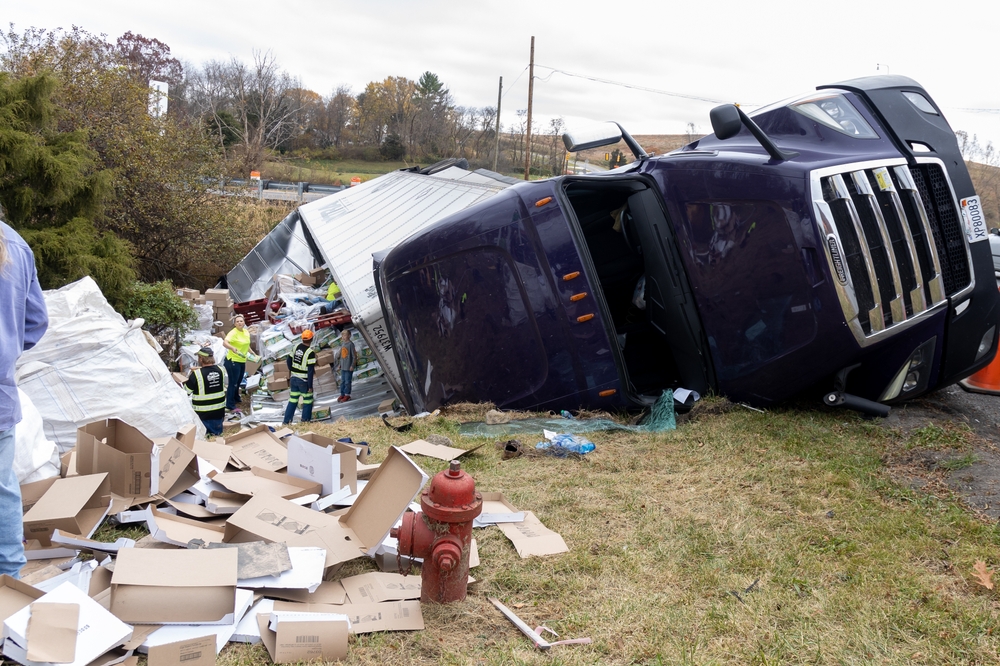 overturned truck on a road in an accident. rescuers clearing debris after an accident